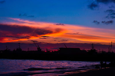 Scenic view of sea against dramatic sky during sunset