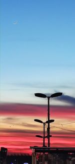 Low angle view of illuminated ferris wheel against sky during sunset