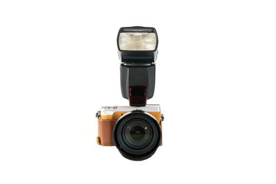 High angle view of camera with flash light against white background