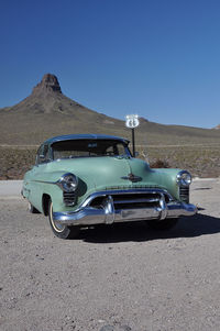 Cars on road against clear blue sky