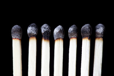 Close-up of burnt matchsticks against black background