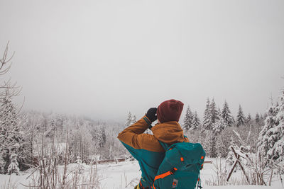 Rear view of woman standing against clear sky