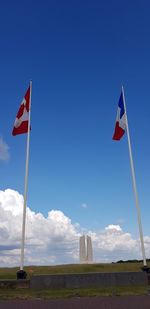 Low angle view of flag against blue sky