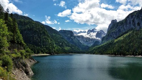 Scenic view of lake by mountains against sky