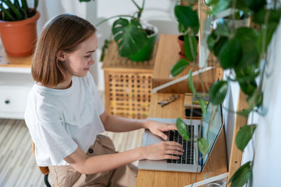 Young woman working on laptop from home.