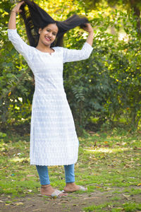Full length of happy woman standing in park
