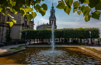 Fountain in city against sky