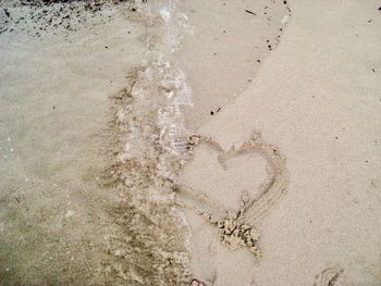 High angle view of heart shape on sand at beach