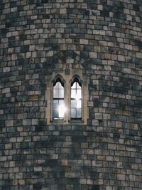 Low angle view of illuminated window on brick wall