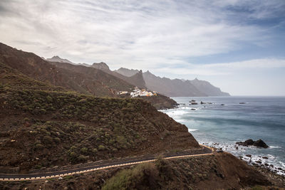 Scenic view of sea and mountains against sky