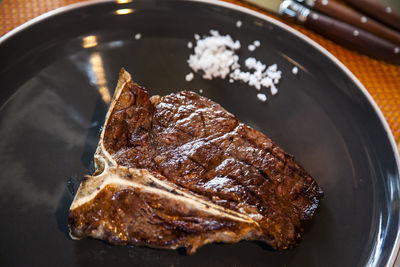 High angle view of steak and salt served on table