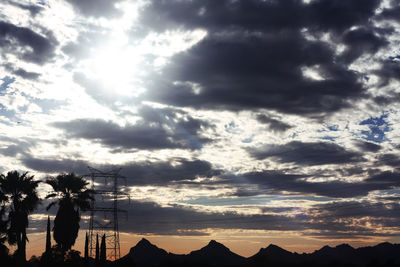 Scenic view of mountains against cloudy sky at sunset