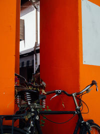 Bicycle against orange wall of building