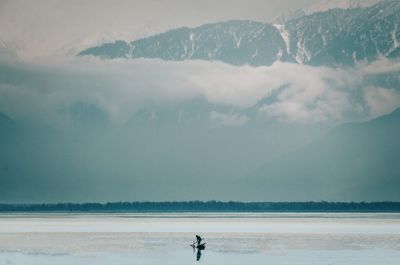 Scenic view of snowcapped mountains and boat in the lake