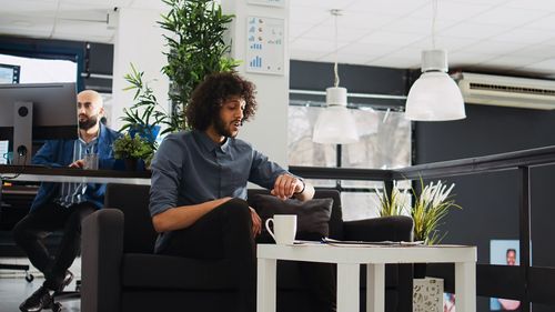 Young woman using laptop while sitting in office