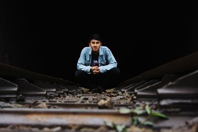 Full length portrait of young man sitting on floor