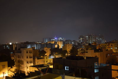 Illuminated cityscape against sky at night