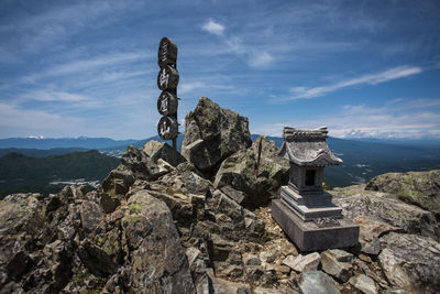 Sculpture on rock against sky