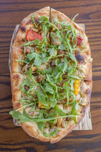 Close-up view of an italian vegetable flatbread on a wooden board