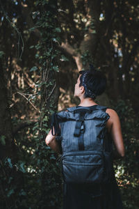 Rear view of woman standing in forest