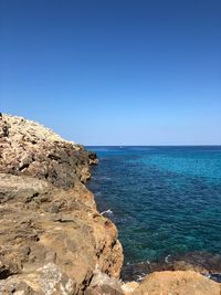 Scenic view of sea against clear blue sky