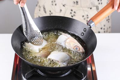 High angle view of hand holding cooking in container