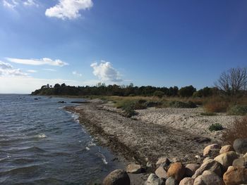 View of calm beach against blue sky