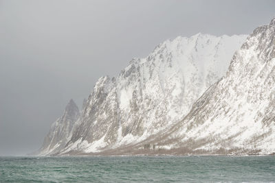 Scenic view of sea and mountains against clear sky