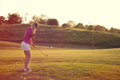 Full length of boy playing on golf course