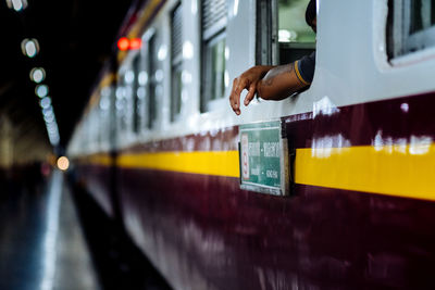 Cropped hand of man sitting in train