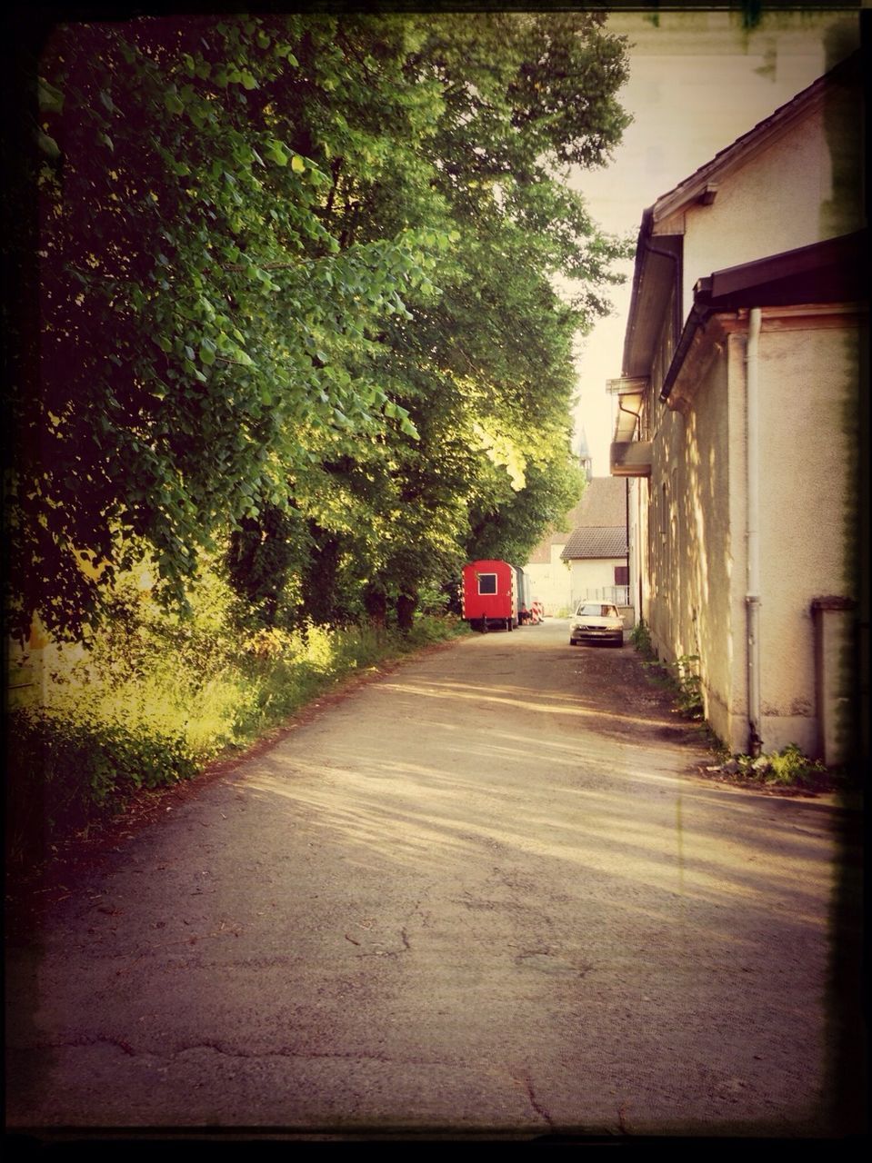 transportation, the way forward, road, transfer print, tree, building exterior, street, architecture, auto post production filter, built structure, diminishing perspective, mode of transport, land vehicle, road marking, car, vanishing point, sky, outdoors, house, red