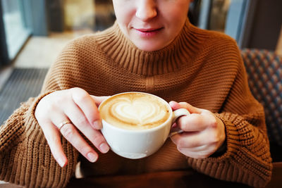 Midsection of woman holding coffee cup