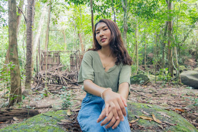 Young woman sitting in a forest