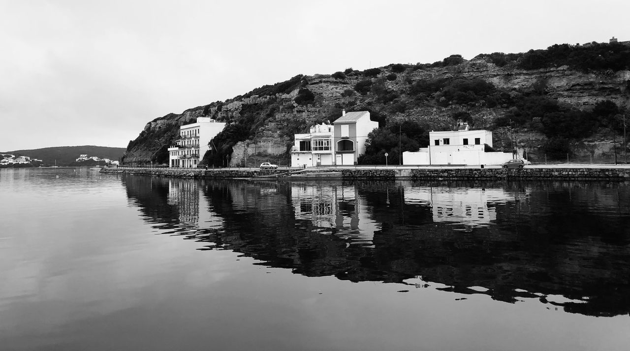 water, reflection, architecture, sky, black and white, built structure, building exterior, building, nature, monochrome photography, monochrome, house, lake, no people, travel destinations, mountain, tranquility, scenics - nature, residential district, land, outdoors, day, beach, waterfront, travel, coast, tranquil scene, beauty in nature, landscape, tourism, cloud, history, tree, environment