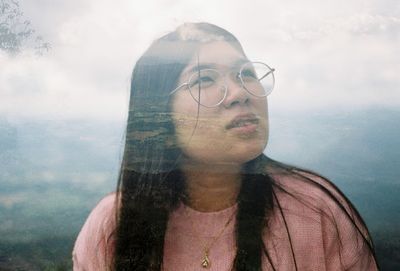 Close-up of young woman against sky