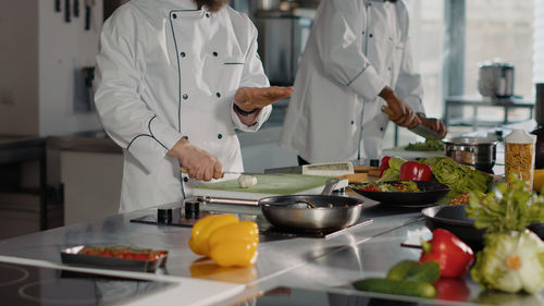 Midsections of chefs working in kitchen