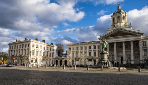 Buildings in city against cloudy sky