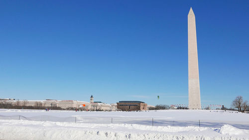 Scenic view of snow covered field against clear blue sky