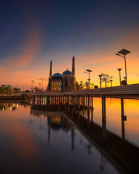 View of illuminated mosque against sky during sunset