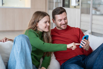 Portrait of smiling friends sitting at home