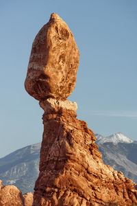 Rock formation by mountain against sky