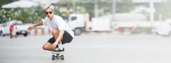 Portrait of man crouching on skateboard