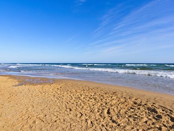 Scenic view of beach against blue sky