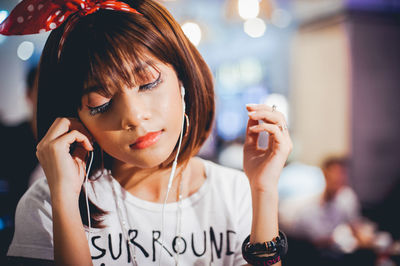 Close-up of young woman listening music