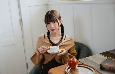 Young woman using mobile phone at home
