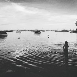 View of boy in sea against sky