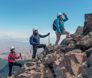 Low angle view of people climbing on rocks