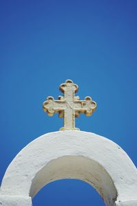 Low angle view of cross against clear blue sky