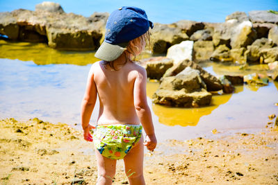 Full length of shirtless boy on beach