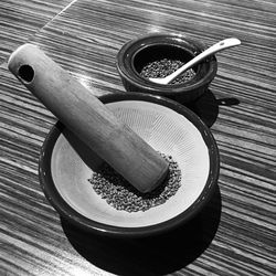 High angle view of mortar and pestle with grains by bowl on table